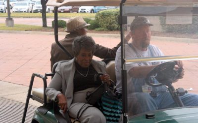 TI retirees ride a golf cart to the TI Retiree Luncheon in November, 2016